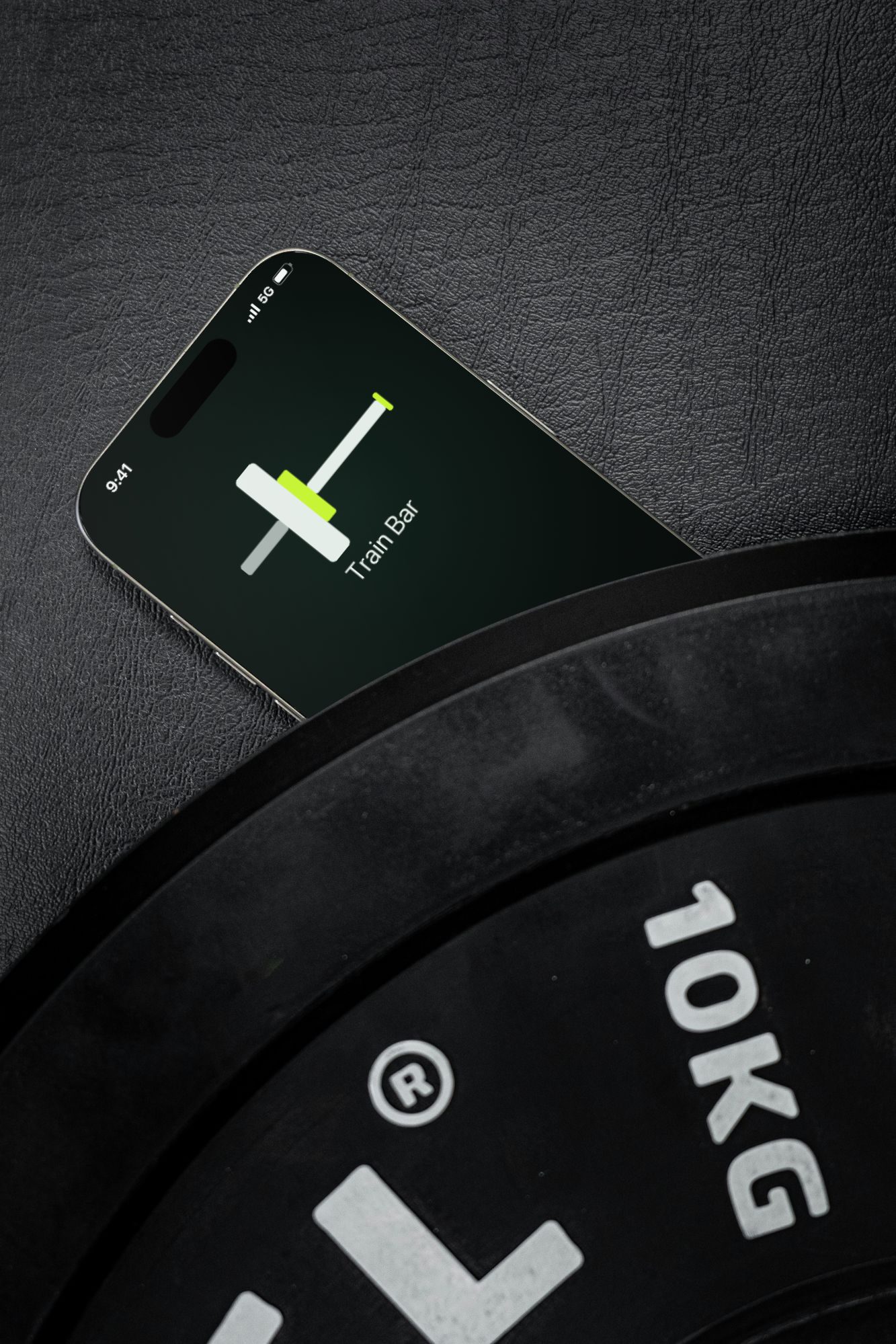 The Train Bar app open on an iPhone, lying next to a weight plate